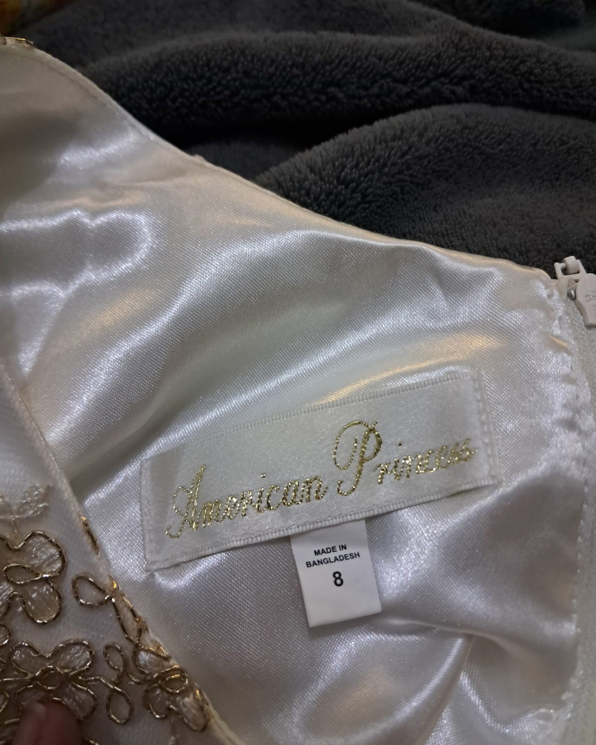 Vestido de niña en blanco con detalles dorados y lazo fucsia
