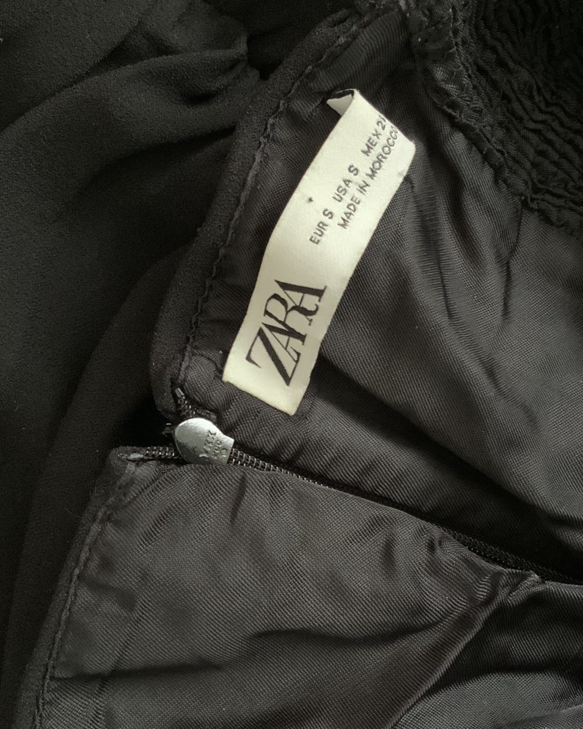 Vestido negro de mujer con detalle fruncido de Zara
